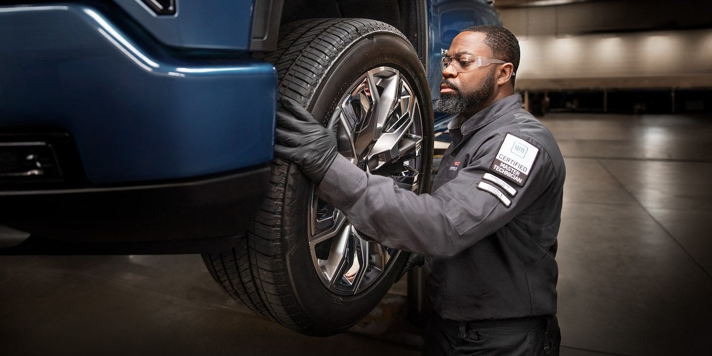 GMC Certified Service technician mounting a wheel and tire on a GMC SUV in Graham, TX