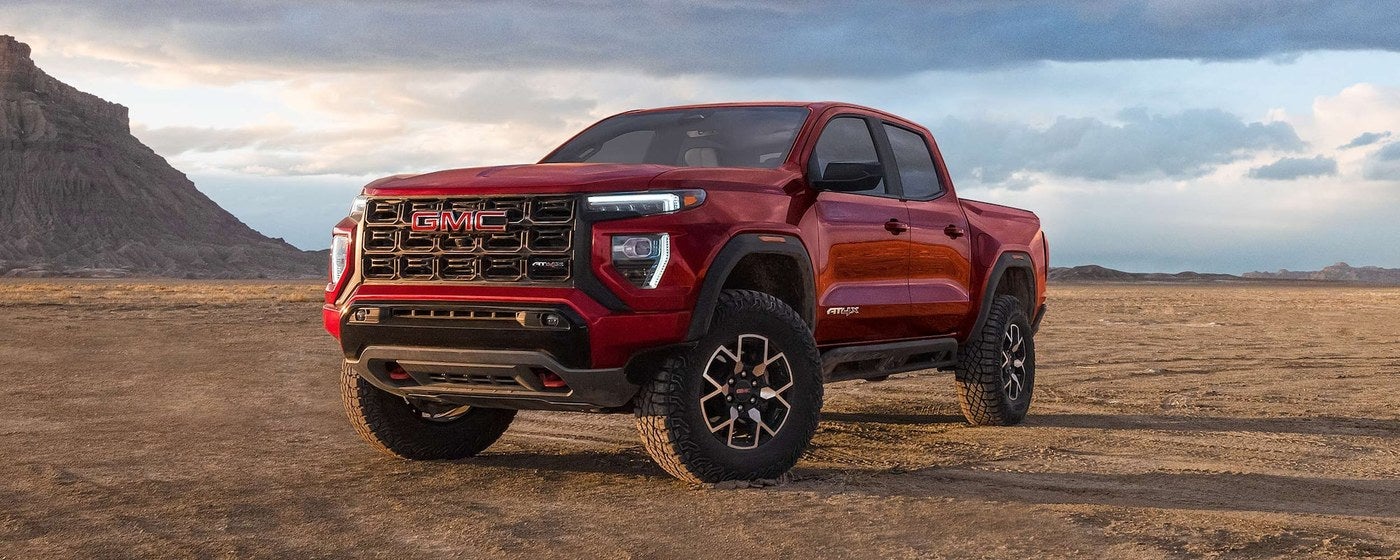 Red GMC Canyon midsize pickup parked in a desert setting