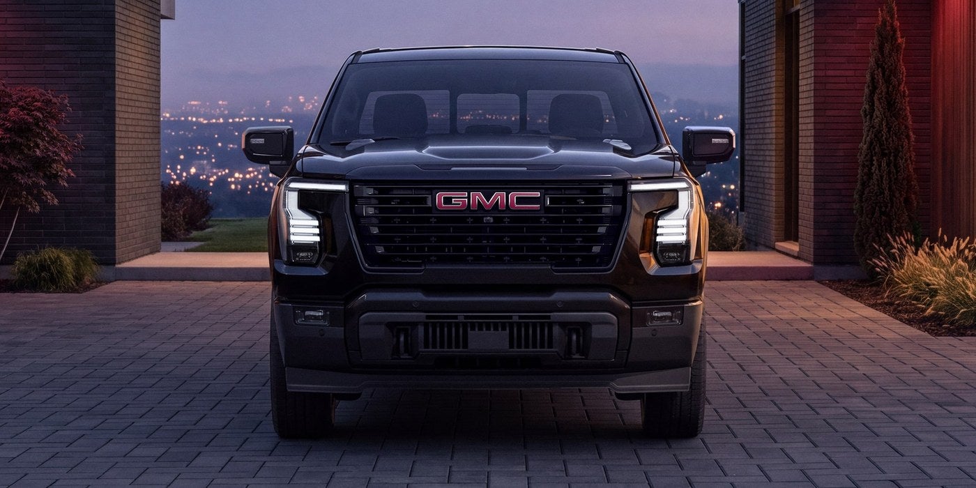 Black GMC Sierra 1500 parked in a paved driveway at dusk