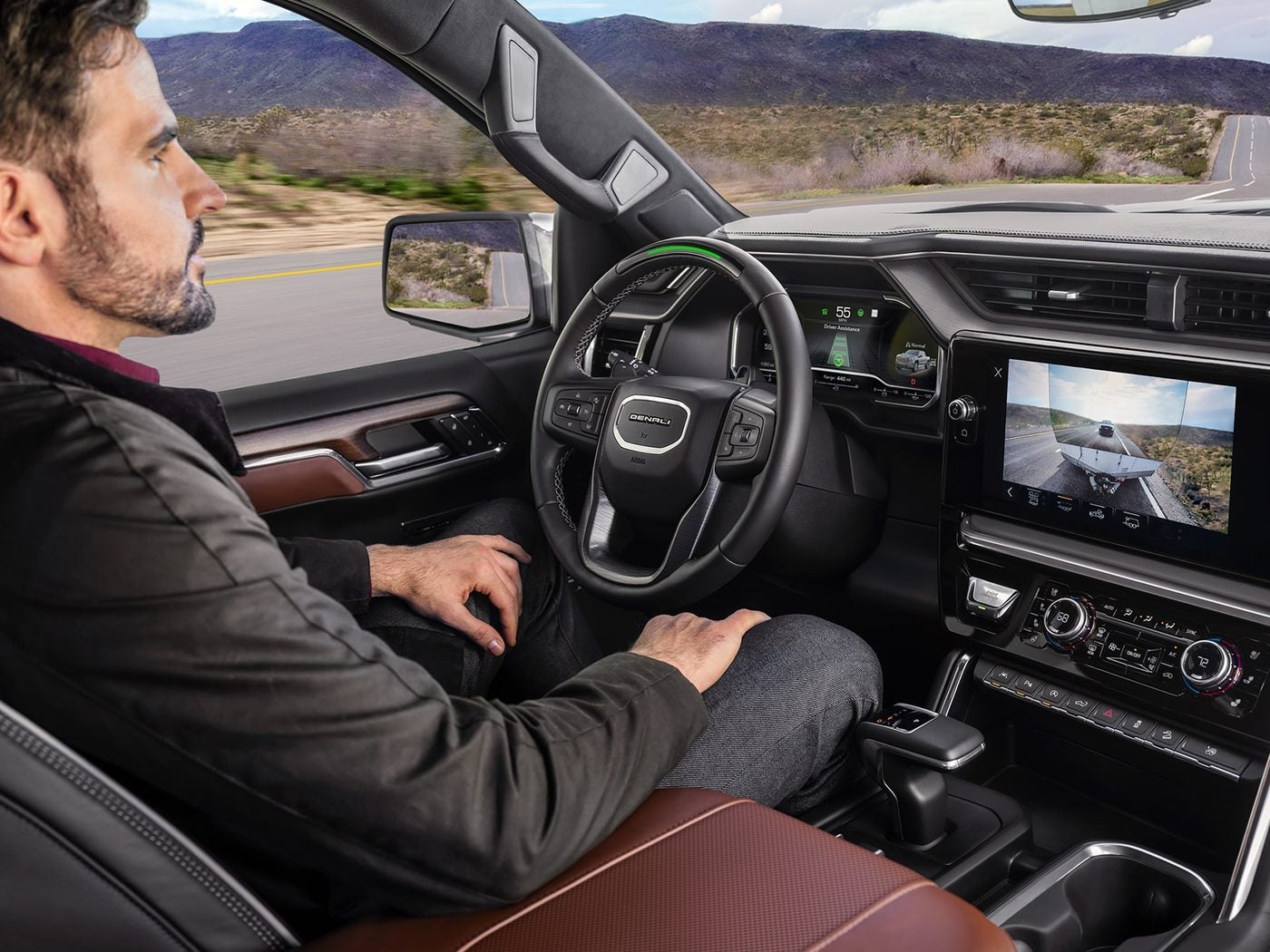 Man driving a GMC Sierra 1500 hands free with Super Cruise on a desert highway